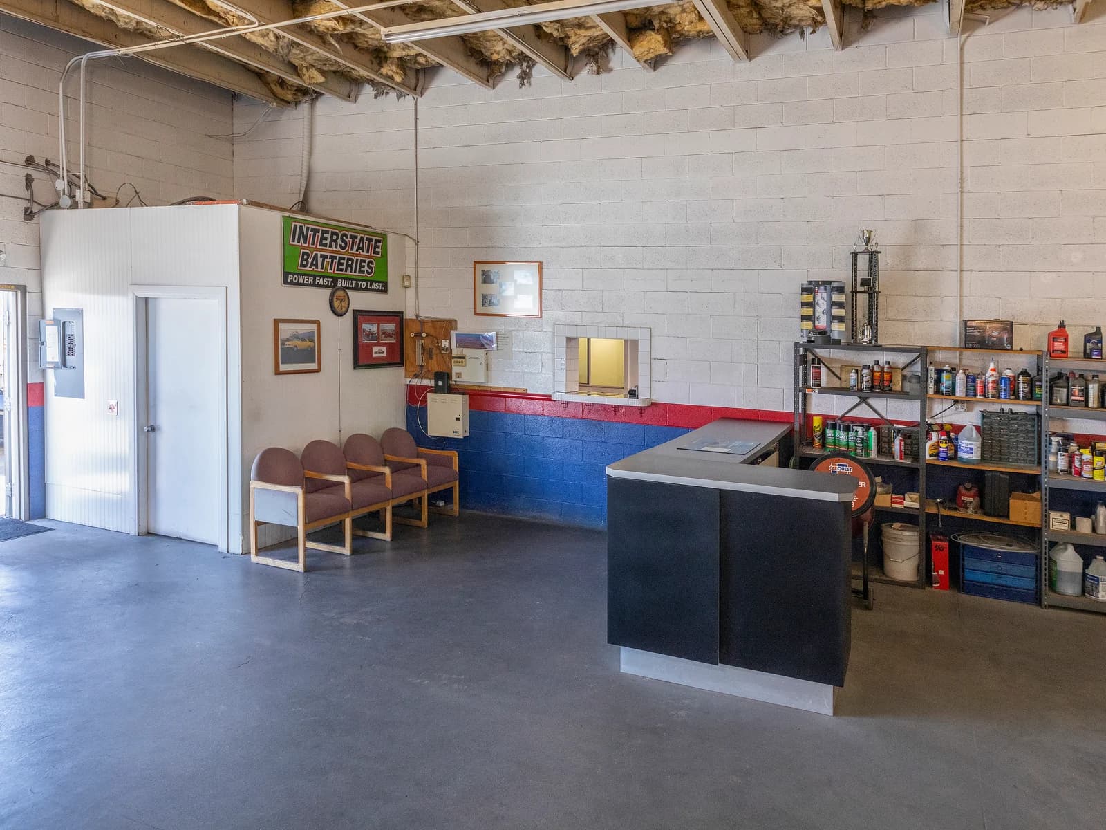 Service counter, waiting chairs and shelves of products inside the Import Auto Pros shop