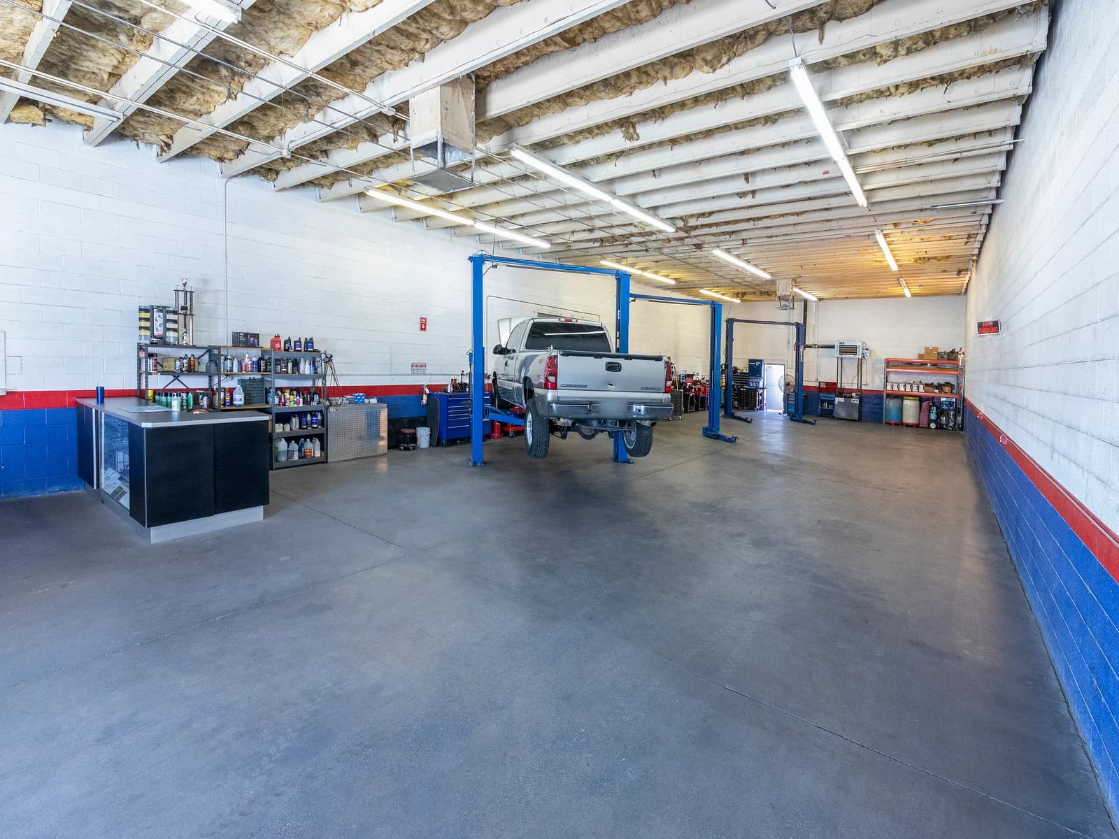 Long view of the shop with a pickup truck on a lift at the far end