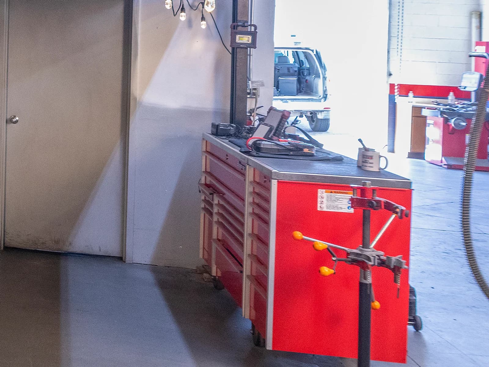 Red tool cart with a vise and a work light in the shop