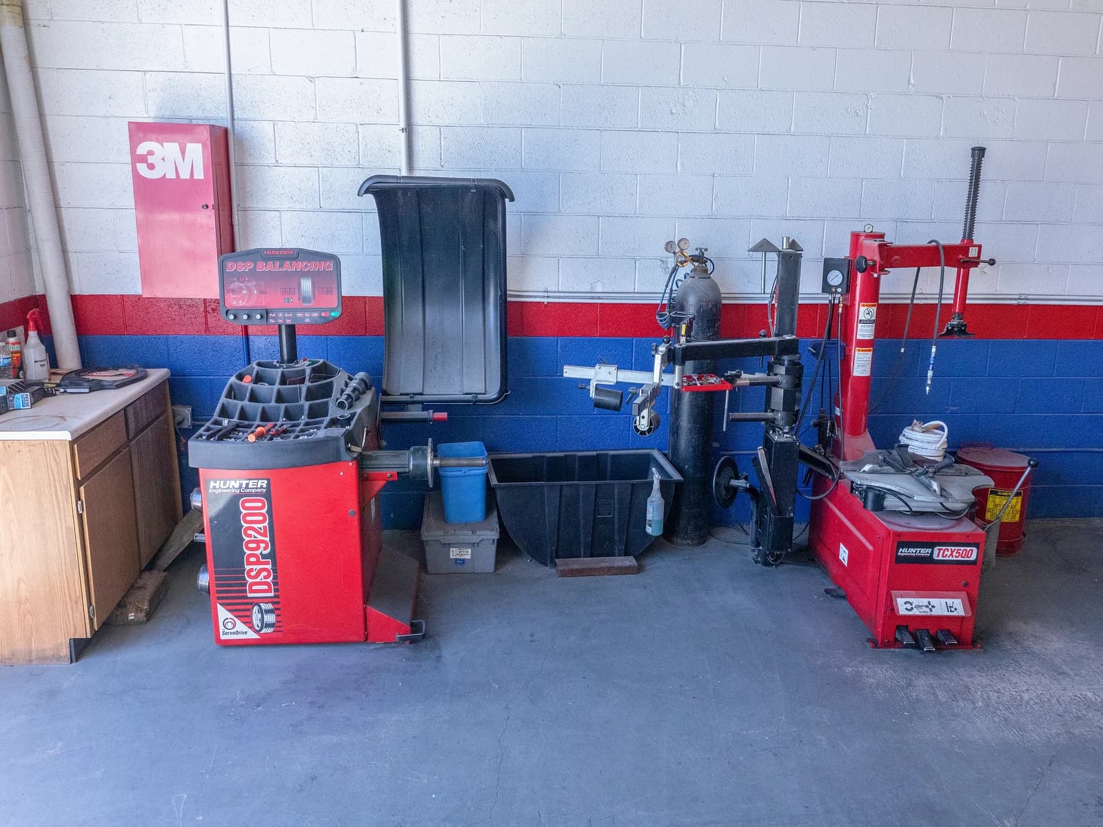 Tire changer and wheel balancer in a corner of the shop