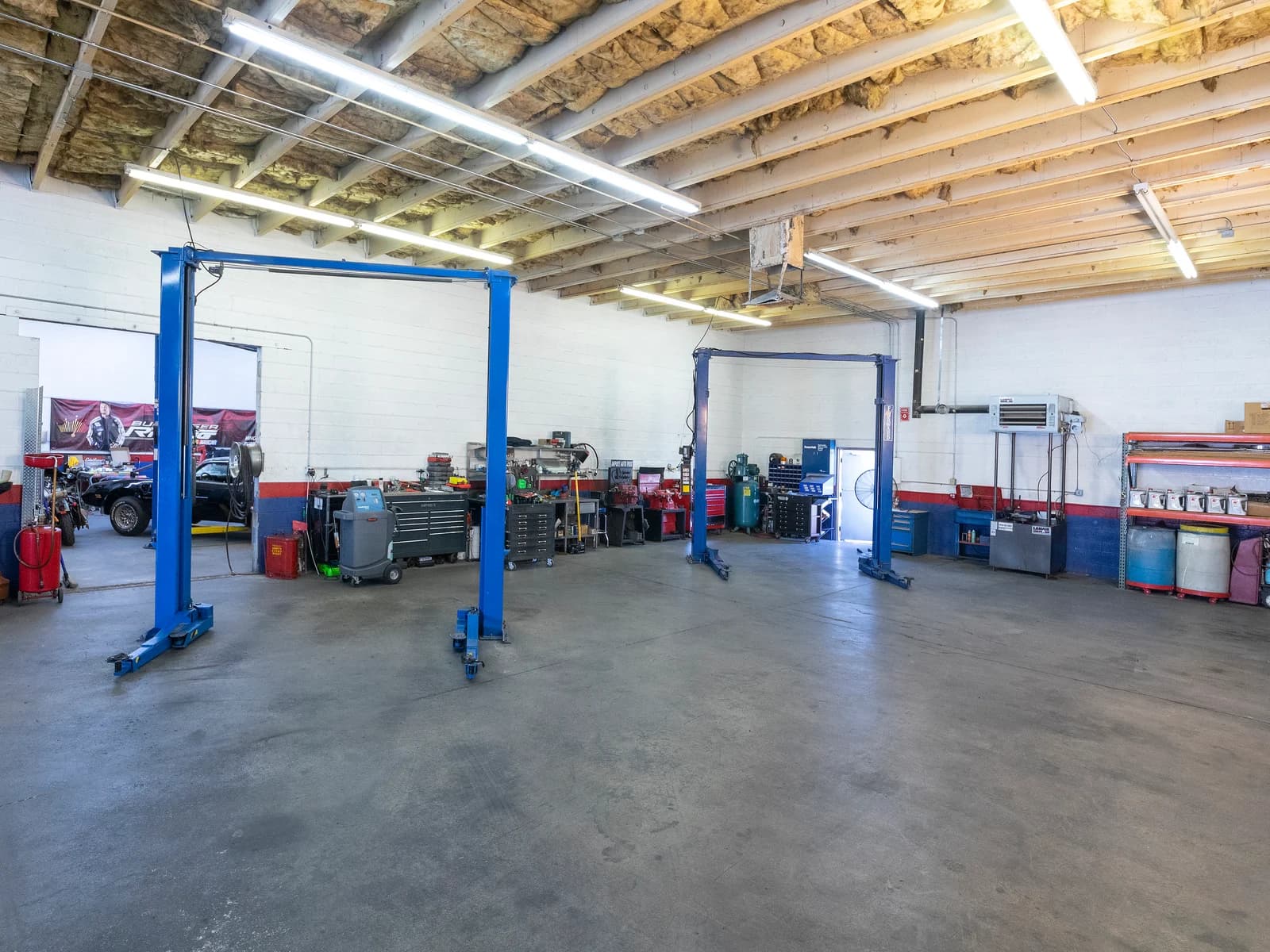 Two service bays with blue lifts inside the Import Auto Pros shop